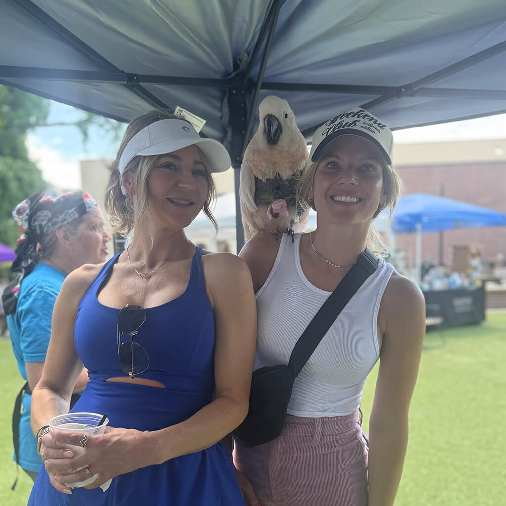 Daniels family with a white cockatoo on her shoulder under a tent