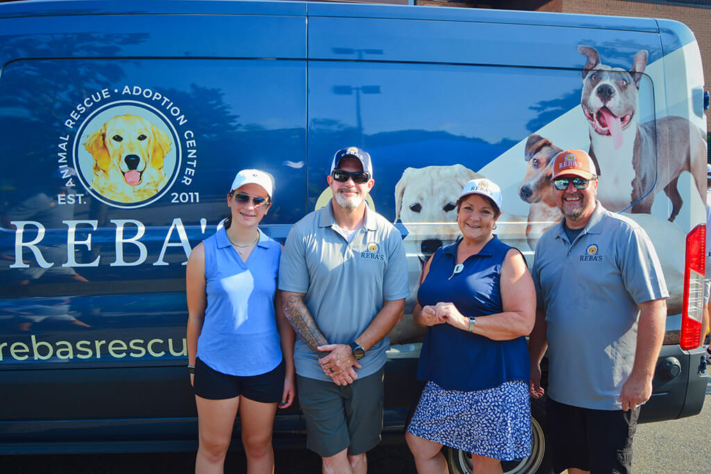 This was team 1. A group of four people in front of the Rebas van. Two men and two women in blue clothing.