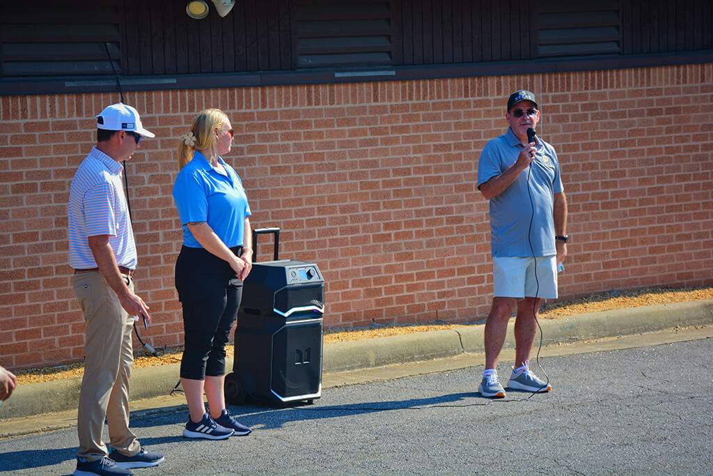 Charlie Daniels talking in the mic on the right with Meagan on the left of the speaker system and guy in white hat next to her