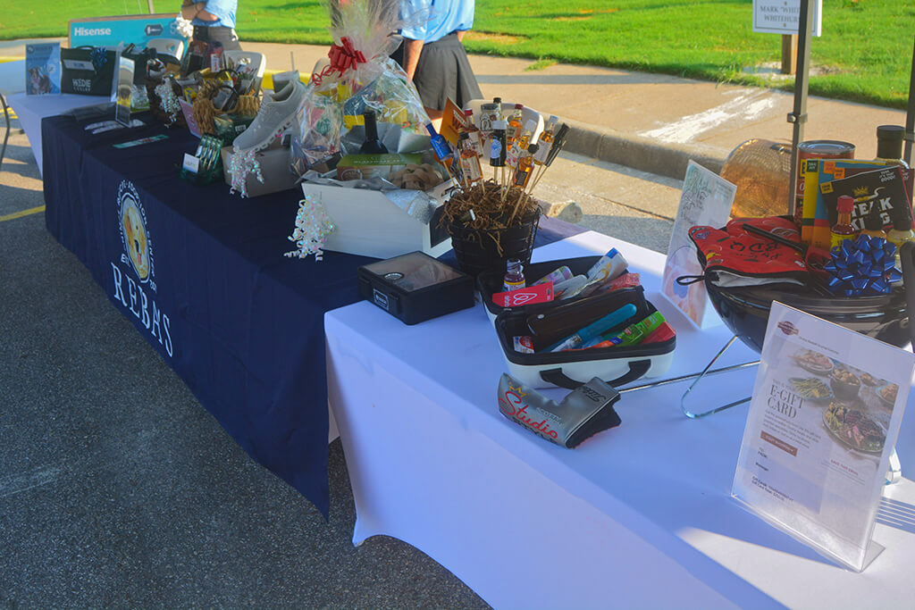 Three tables full of giveaways, gift baskets and prizes