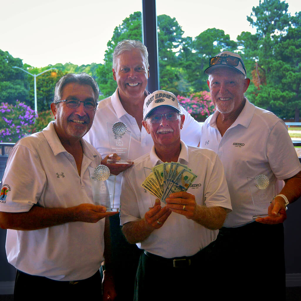 Team 9 consisted of 4 men in white shirts proudly showing off three trophies and cash winnings fanned out in front of them.
