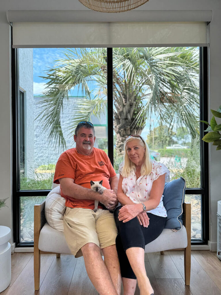 Family of 2 holding Elvis, a siamese mix kitten