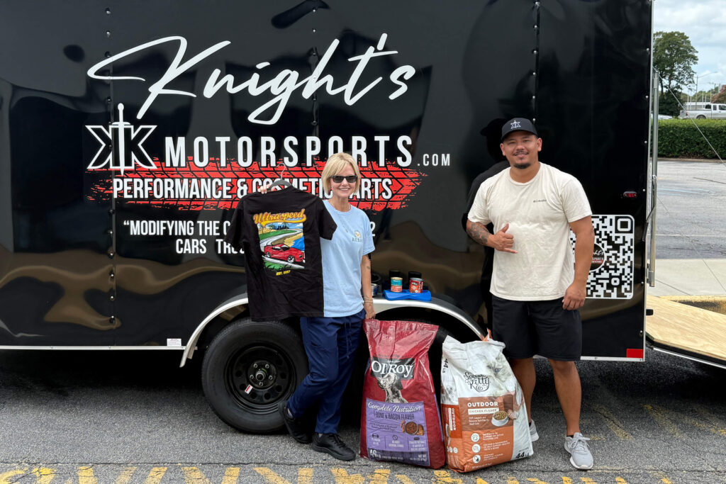 Justin and Michele in front of Knights motorsports trailer with donations of food