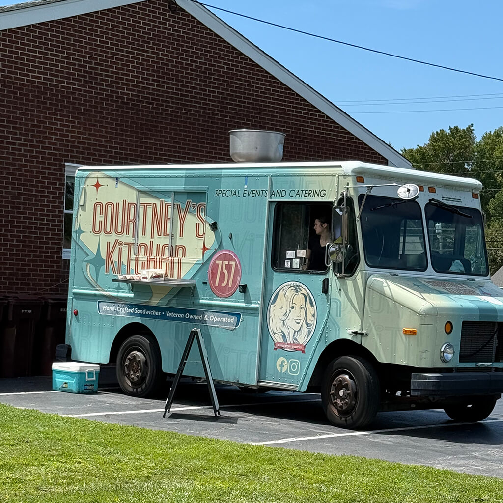 A teal colored, retro looking, Food truck called Courtney's Kitchen
