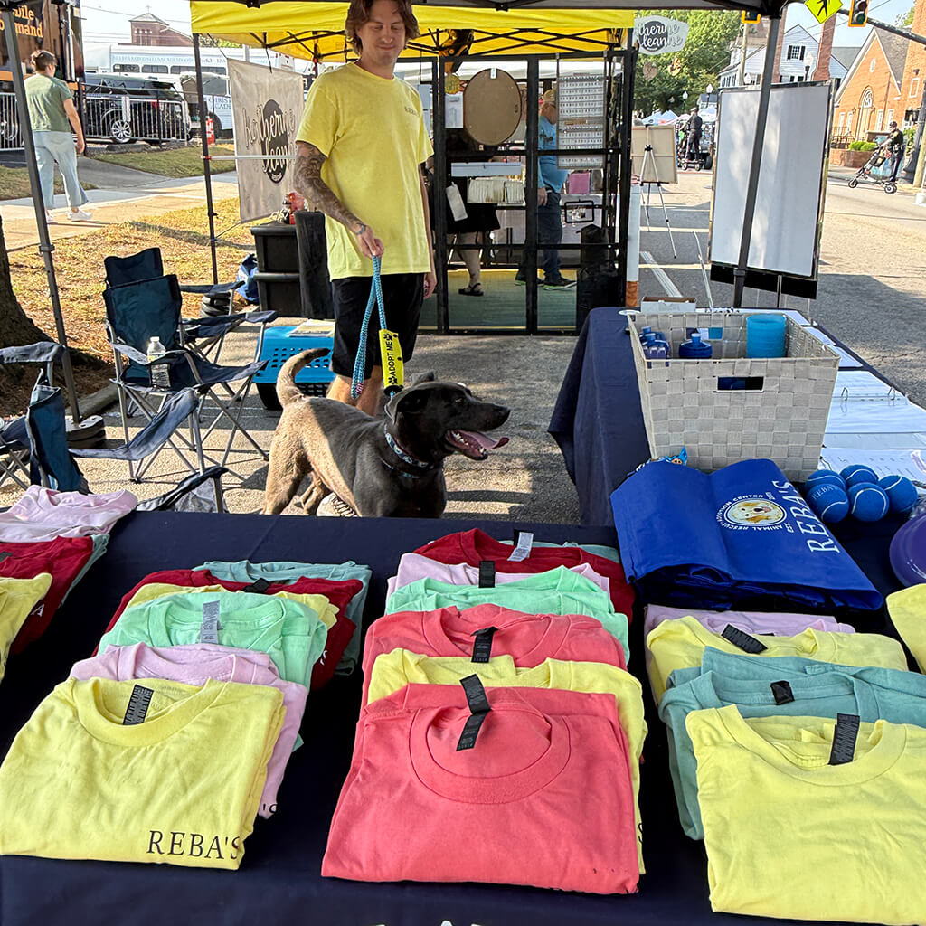 Lots of colorful shirts for sale under Reba's tent