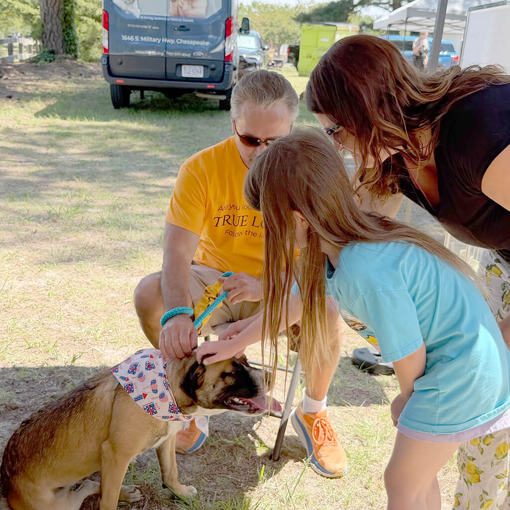 Visitors pet the adoptable dog.